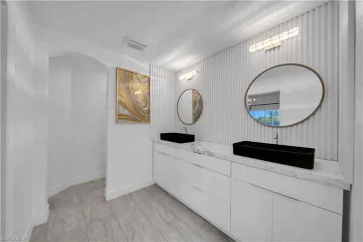 Bathroom with double vanity and baseboards