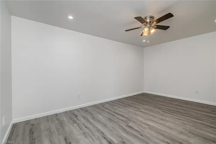 Spare room featuring light wood-style flooring, ceiling fan, and recessed lighting