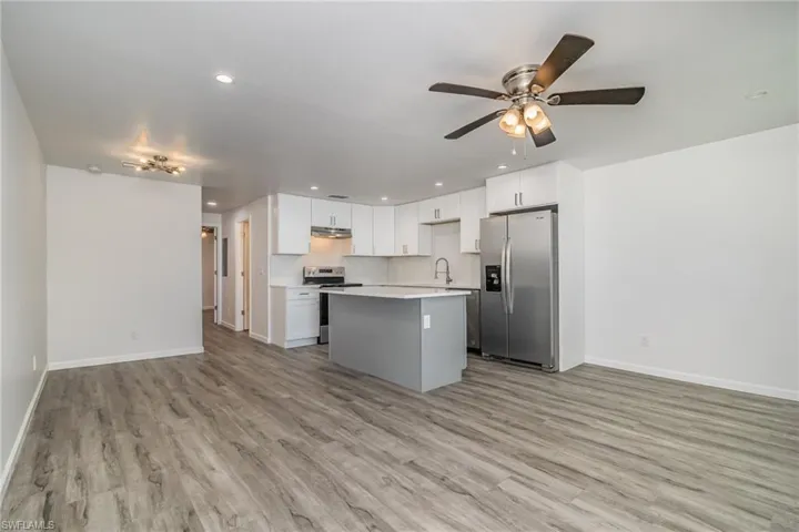 Kitchen with open floor plan, stainless steel appliances, ceiling fan, a kitchen island, and recessed lighting