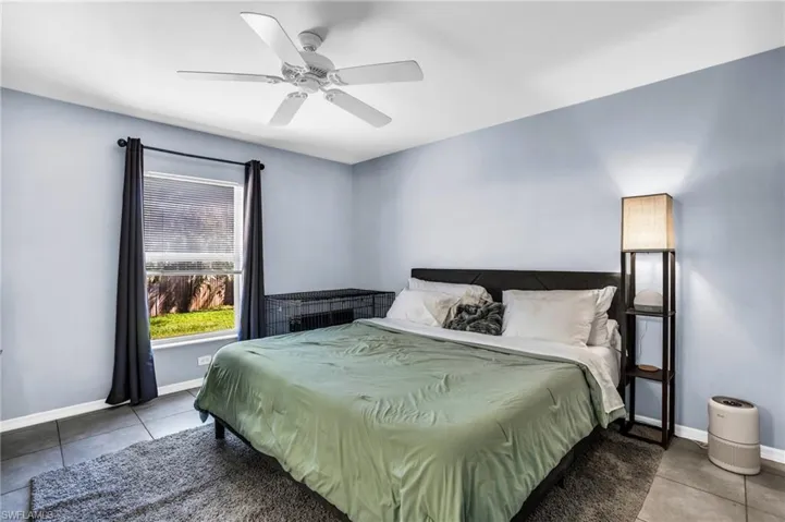 Bedroom with tile patterned flooring and ceiling fan
