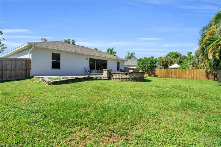 Rear view of property with a lawn