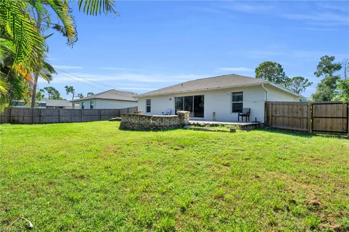 Back of house featuring a patio area and a lawn