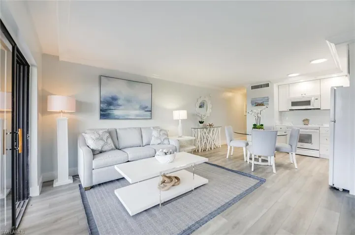 Living room featuring crown molding, light wood-style floors, and recessed lighting