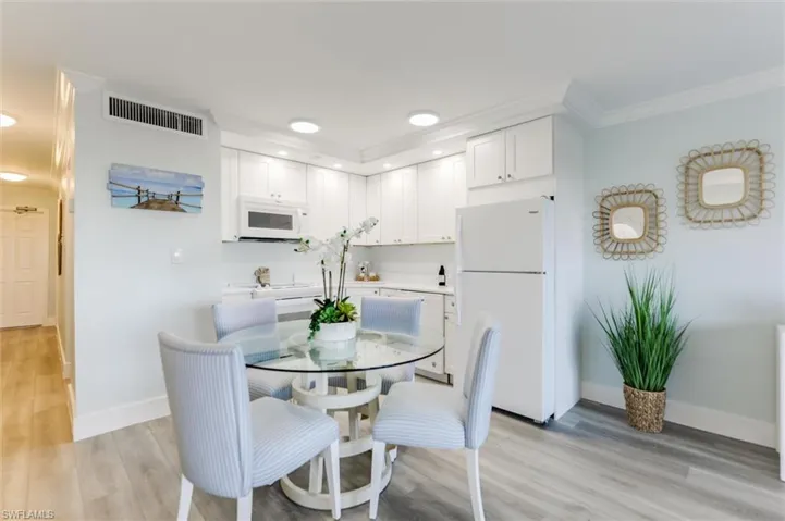 Dining room with light wood-type flooring, crown molding, and recessed lighting