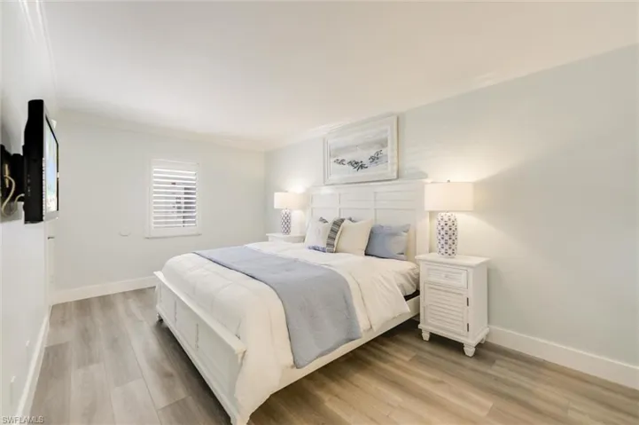 Bedroom featuring crown molding and light wood finished floors