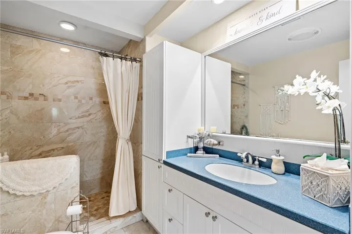 Bathroom featuring vanity and tiled shower
