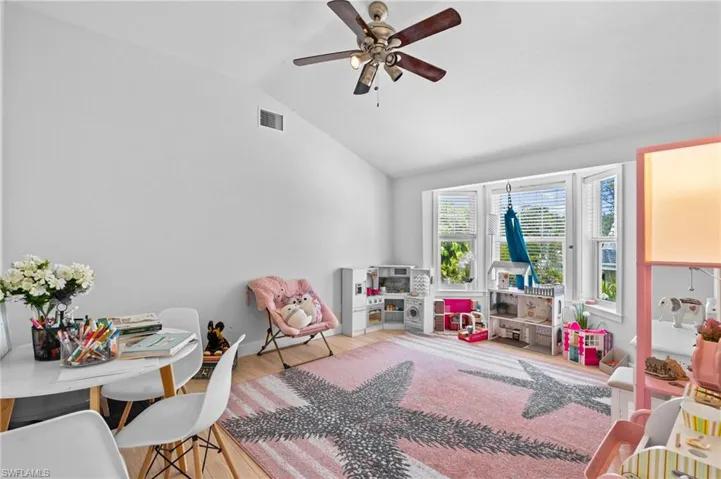 Recreation room with vaulted ceiling, wood finished floors, and a ceiling fan