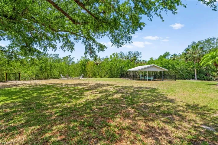 View of green lawn featuring a view of trees