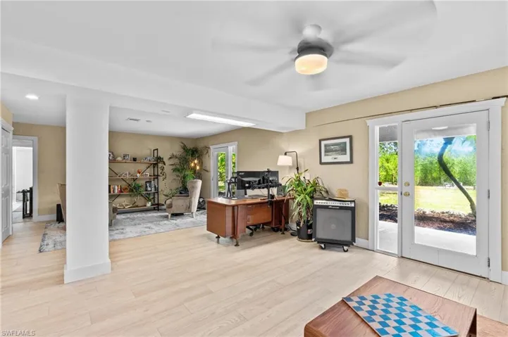 Home office with light wood finished floors and a ceiling fan