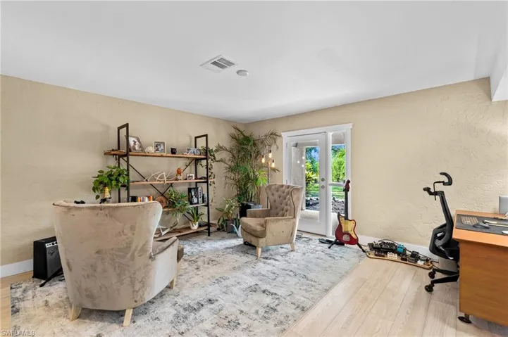 Home office featuring a textured wall, french doors, and wood finished floors