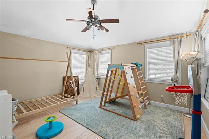 Bedroom featuring wood finished floors, ceiling fan, and multiple windows