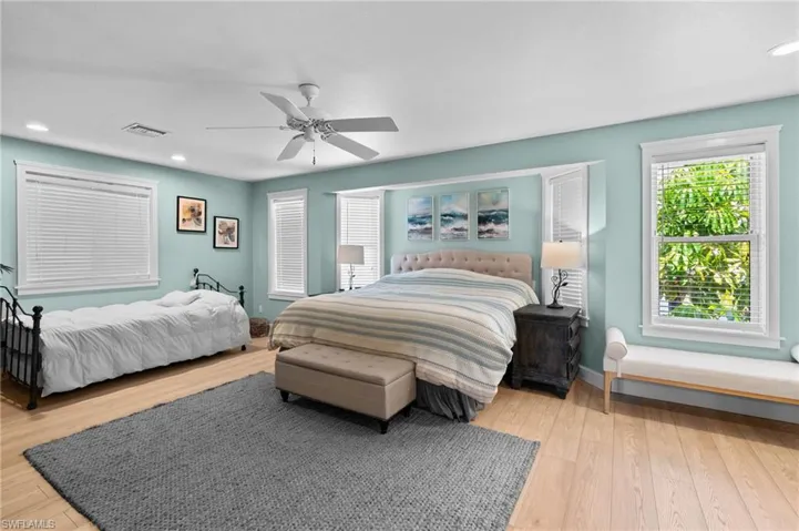 Bedroom with recessed lighting, light wood finished floors, a ceiling fan, and multiple windows