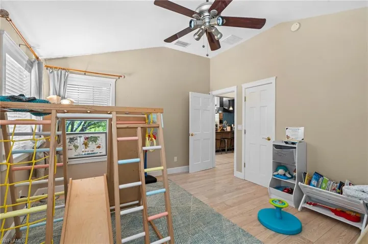 Bedroom featuring vaulted ceiling, light wood-type flooring, and ceiling fan