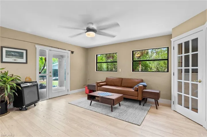Living area featuring french doors, healthy amount of natural light, and light wood-style flooring