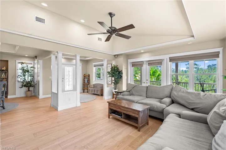 Living room featuring ceiling fan, light wood-style floors, recessed lighting, healthy amount of natural light, and vaulted ceiling