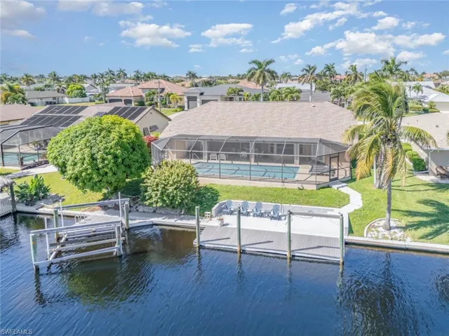 Dock area featuring an outdoor pool, a lanai, a residential view, a lawn, and a sunroom