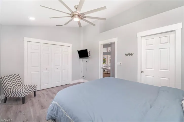 Bedroom featuring wood finished floors, lofted ceiling, a closet, recessed lighting, and ceiling fan