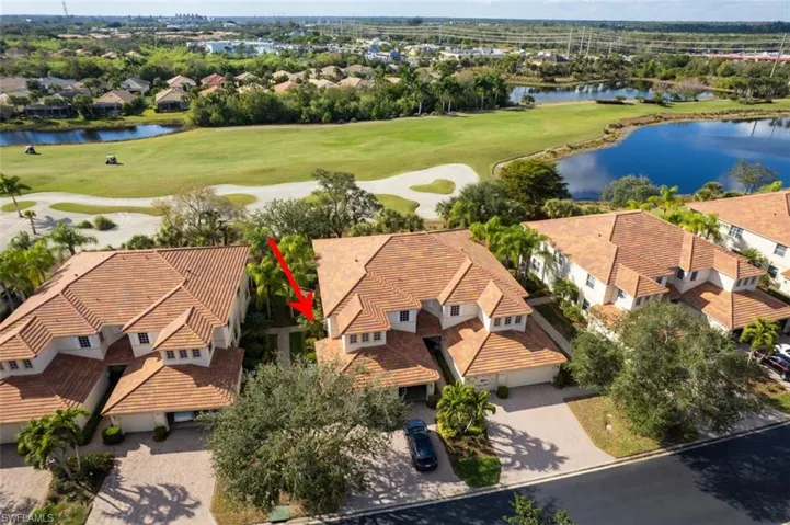 Aerial view of residential area featuring a large body of water and a golf course
