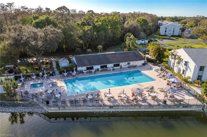 View of pool with a water view, a patio, and an outbuilding