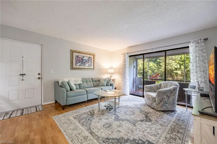 Living room with wood-type flooring and a textured ceiling