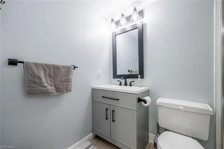Bathroom with vanity, tile patterned floors, and toilet
