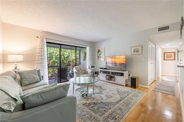 Living room with light hardwood / wood-style flooring and a textured ceiling