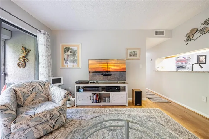 Living room with wood-type flooring and a textured ceiling