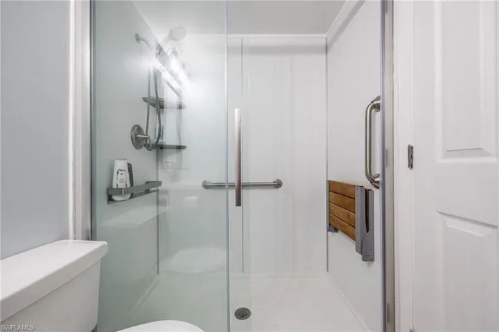 Bathroom featuring toilet and a shower with shower door