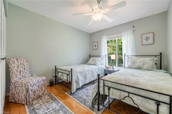 Bedroom featuring ceiling fan, a textured ceiling, and light hardwood / wood-style flooring