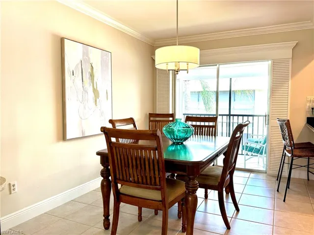 Here is the separate dining area just off the kitchen for your convenience. Notice the woodwork lanai surround and the crown mold continues throughout all the rooms. The classic furniture comes with the home