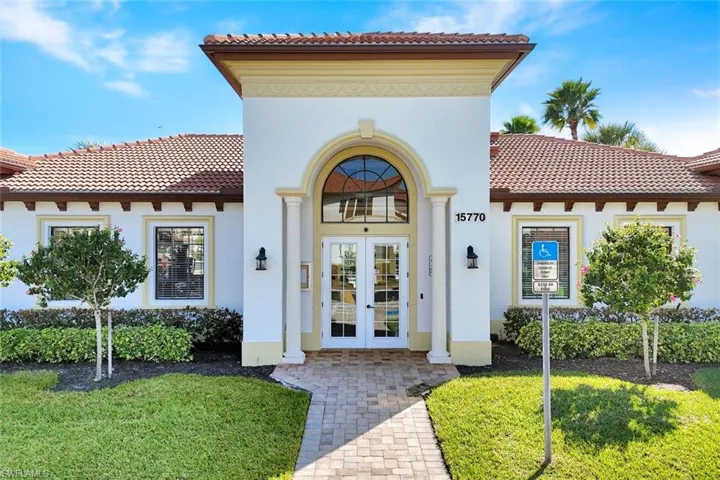 Property entrance featuring french doors, stucco siding, a tile roof, and a yard
