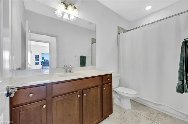 Full bath with vanity, light tile patterned floors, a chandelier, and shower / bathtub combination with curtain