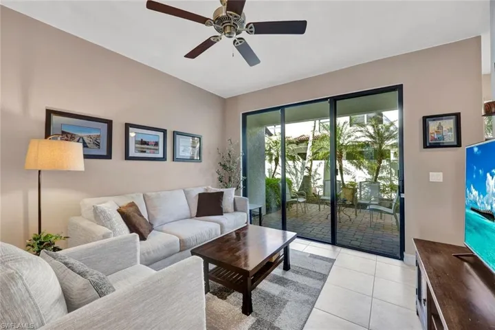 Living room featuring a ceiling fan and light tile patterned floors