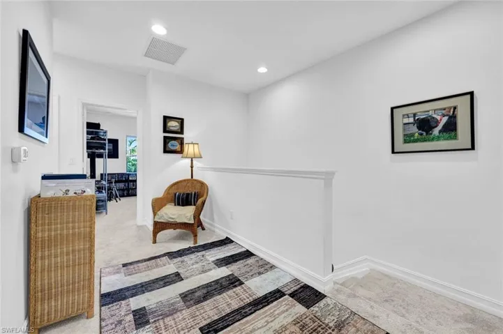 Living area with light colored carpet and recessed lighting