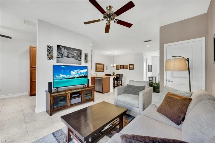 Living area with a ceiling fan and light tile patterned floors