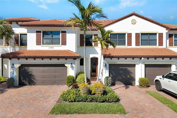 Mediterranean / spanish-style house with an attached garage, a tiled roof, stucco siding, and decorative driveway