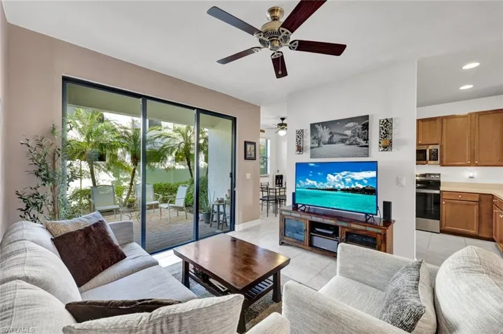Living room featuring light tile patterned flooring, ceiling fan, and recessed lighting