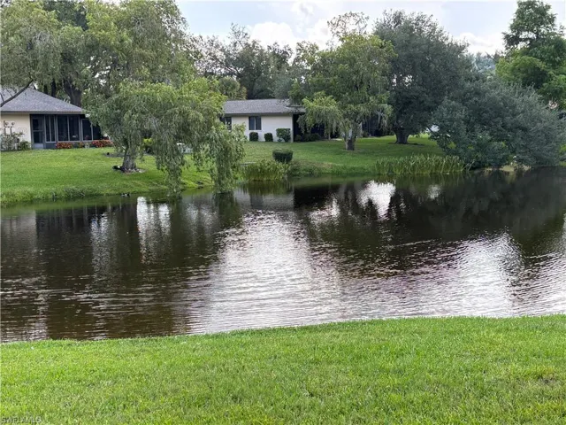 Waterfront property featuring a screened-in porch and mature trees