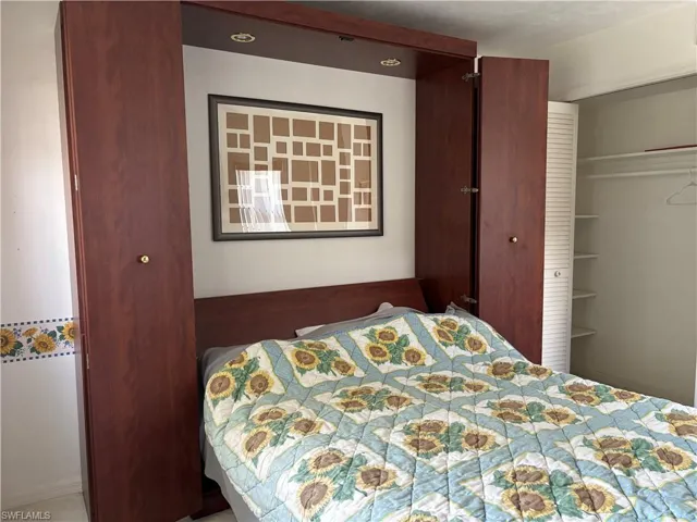 Built-in wall unit featuring a rich wood-finish, integrated lighting, and a coordinating headboard
