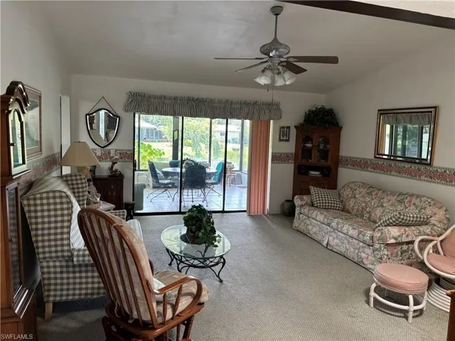 Carpeted living space featuring a sliding glass door to an outdoor patio with tiled flooring