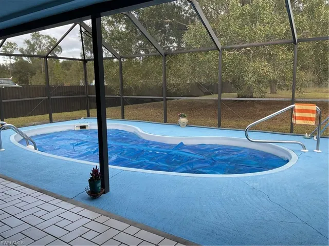 View of basketball court featuring a fenced backyard, a sunroom, and plenty of natural light