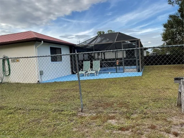 Back of house featuring a sunroom, a fenced backyard, a lanai, a patio area, and a metal roof