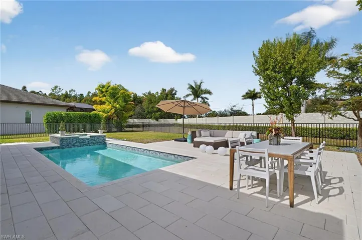 Combined pool / hot tub featuring a fenced backyard, a patio, and an outdoor living / dining area