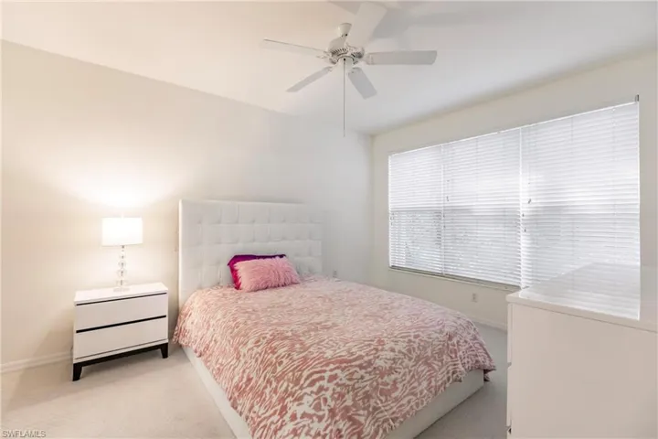 Carpeted bedroom featuring ceiling fan