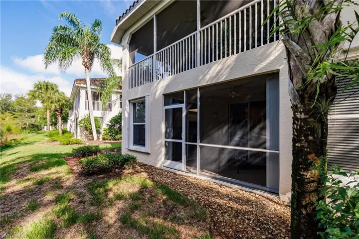 Back of property with a sunroom and a balcony