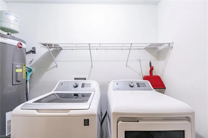 Laundry area featuring washer and dryer and electric water heater