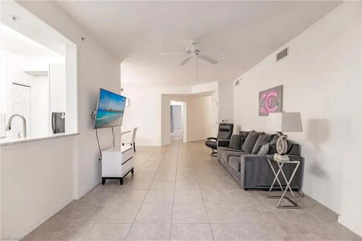 Tiled living room with sink and ceiling fan