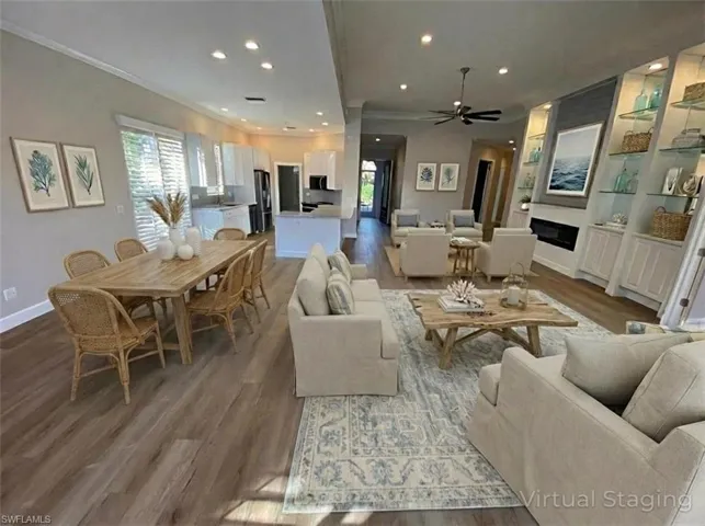 Living area with wood finished floors, ornamental molding, recessed lighting, a ceiling fan, and a fireplace