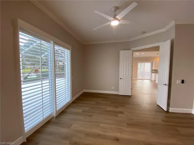 Unfurnished room with light wood-style flooring, ornamental molding, and a ceiling fan