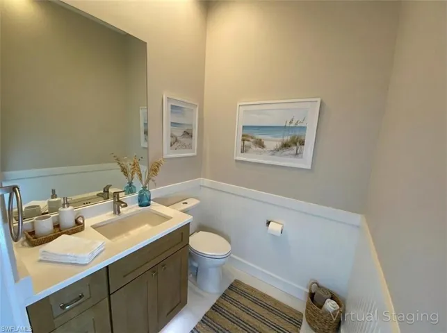 Half bathroom featuring vanity and a wainscoted wall